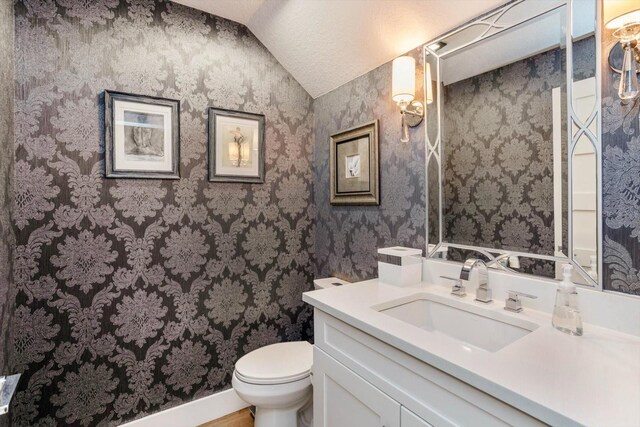 1831 Mizell Ave, Winter Park, FL 32789 - bathroom featuring lofted ceiling, wallpapered walls, toilet, and vanity