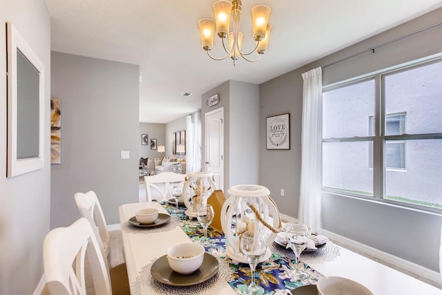 dining room featuring plenty of natural light, a chandelier, and baseboards