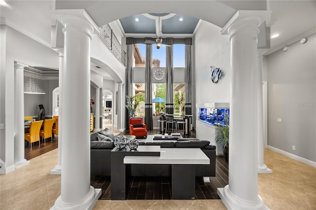 interior space with arched walkways, a high ceiling, tile patterned floors, and ornate columns