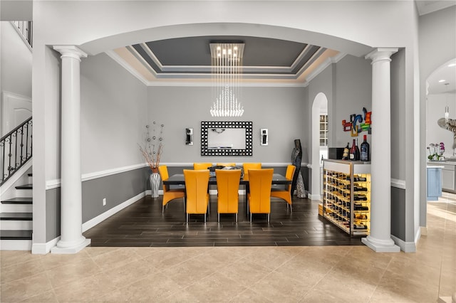 tiled dining space featuring a tray ceiling, stairway, ornamental molding, and arched walkways