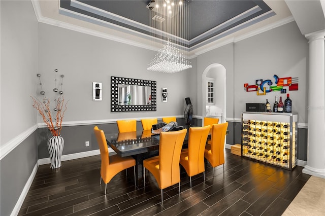 dining room with ornamental molding, a tray ceiling, and wood finished floors