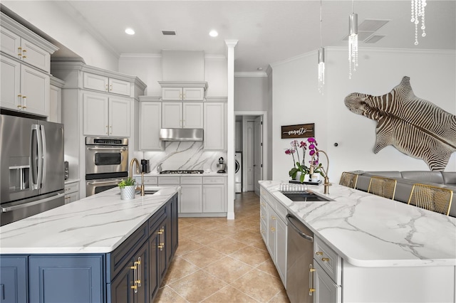 kitchen with stainless steel appliances, a spacious island, ornamental molding, and a sink