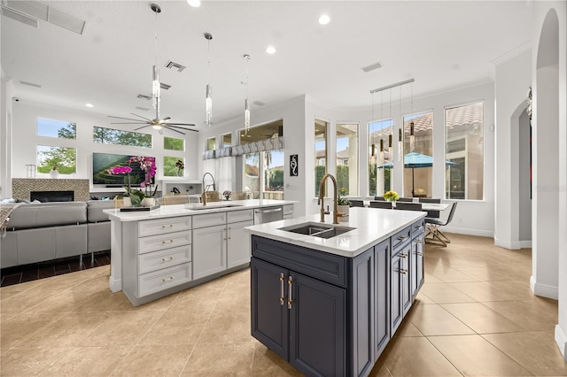 kitchen featuring open floor plan, light countertops, a kitchen island with sink, and a sink