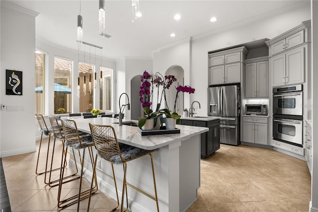 kitchen with a large island, stainless steel appliances, gray cabinetry, and ornamental molding