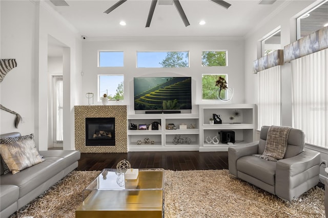 living area featuring a ceiling fan, a healthy amount of sunlight, crown molding, and wood finished floors