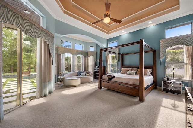 bedroom featuring a raised ceiling, ornamental molding, carpet, and a towering ceiling