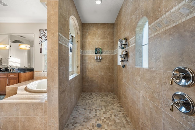 full bath with vanity, visible vents, a bath, and a walk in shower