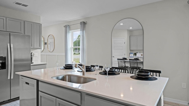 kitchen with light countertops, appliances with stainless steel finishes, visible vents, and a sink