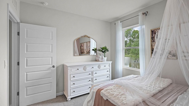 bedroom featuring light colored carpet and baseboards