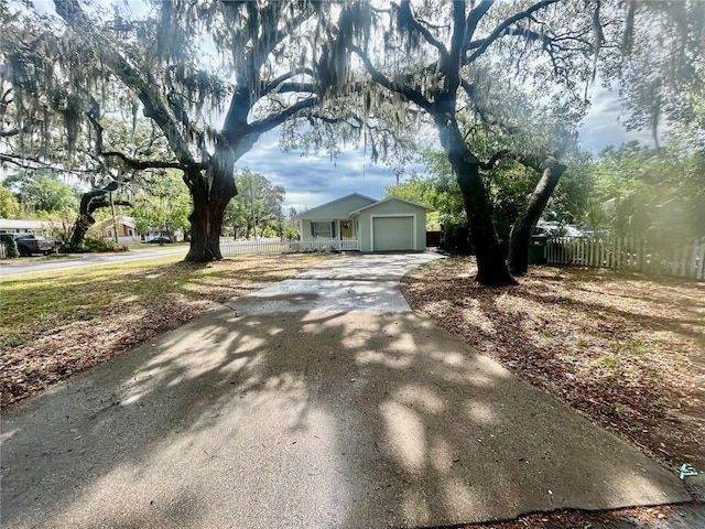 view of front facade with fence, concrete driveway, and an attached garage
