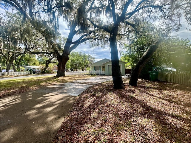 view of front of property with fence, a garage, and driveway