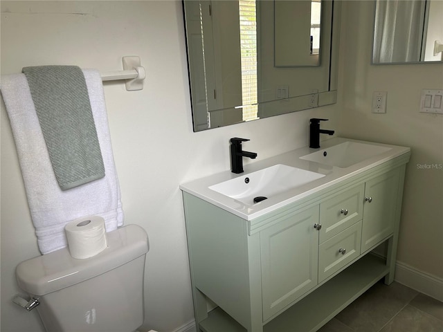 bathroom featuring toilet, double vanity, and tile patterned flooring