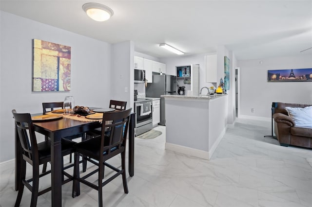 dining area featuring baseboards and marble finish floor