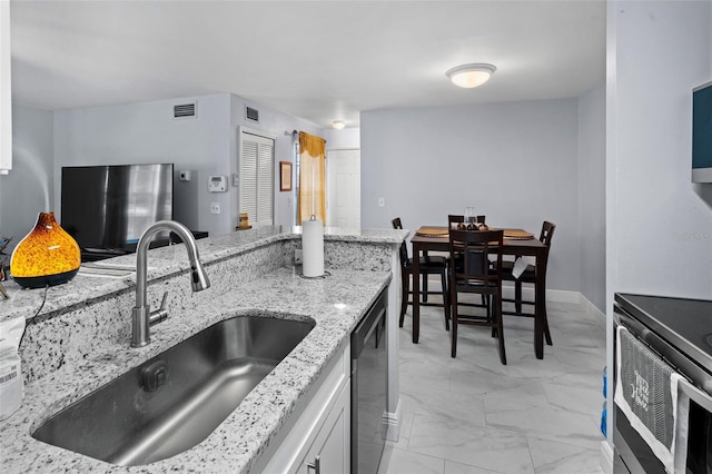 kitchen featuring marble finish floor, light stone counters, visible vents, a sink, and stainless steel appliances