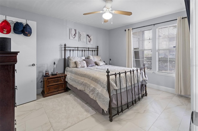 bedroom with ceiling fan and marble finish floor