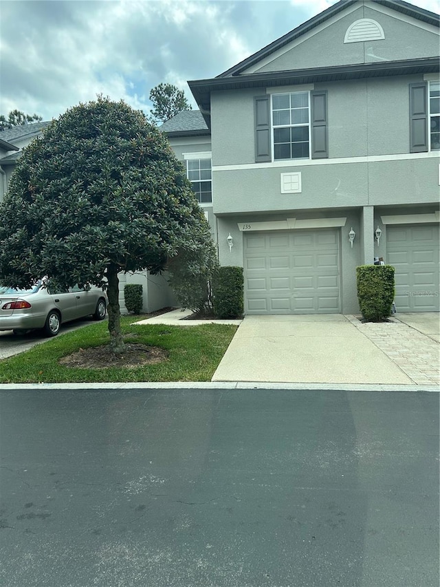 135 Heritage Park St, Winter Springs, FL 32708 - view of front of house with stucco siding, driveway, and a garage