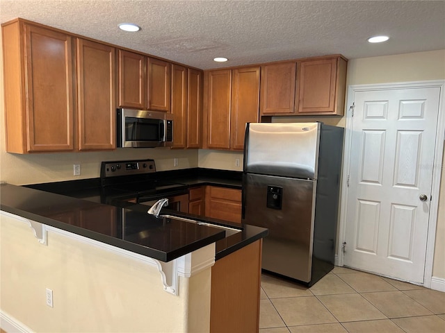 135 Heritage Park St, Winter Springs, FL 32708 - kitchen featuring dark countertops, a peninsula, appliances with stainless steel finishes, and a breakfast bar area