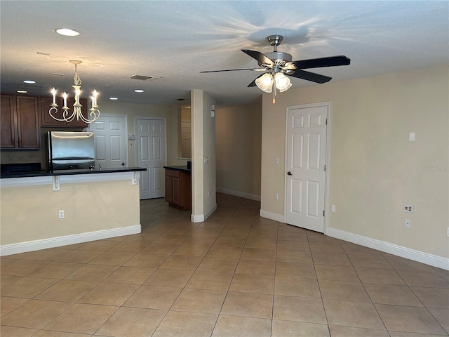 135 Heritage Park St, Winter Springs, FL 32708 - kitchen featuring freestanding refrigerator, light tile patterned floors, visible vents, ceiling fan with notable chandelier, and dark countertops