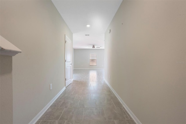 hall featuring baseboards, visible vents, and recessed lighting