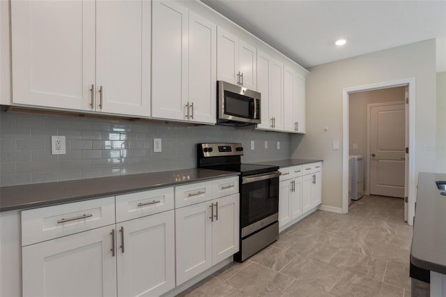 kitchen with backsplash, dark countertops, and appliances with stainless steel finishes