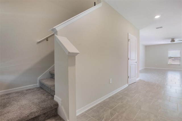 stairs with visible vents, baseboards, and a ceiling fan