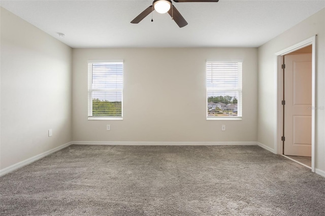 empty room with carpet, baseboards, and a ceiling fan