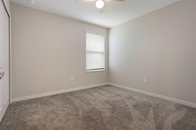 empty room with carpet, baseboards, and a ceiling fan