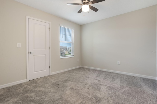carpeted spare room with baseboards and ceiling fan