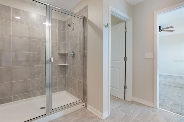 full bathroom with a stall shower, tile patterned flooring, a ceiling fan, and baseboards