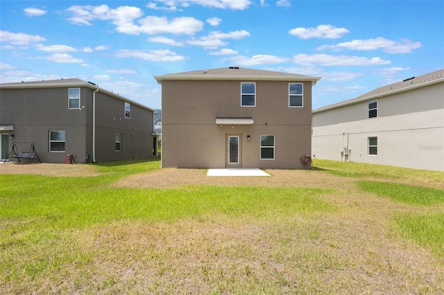 rear view of house with a yard, a patio area, and stucco siding