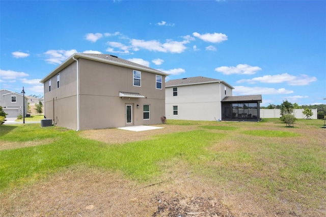 back of house featuring a yard, a patio area, stucco siding, and central AC