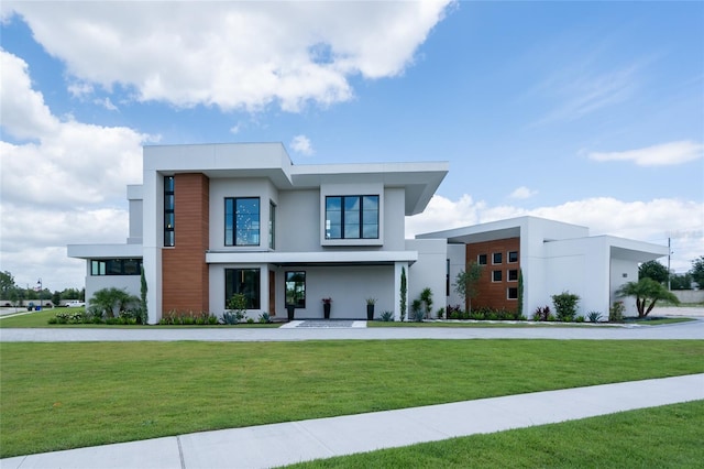 modern home featuring stucco siding and a front yard