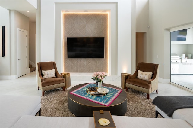 living room featuring baseboards and stairs