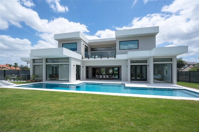 back of house with fence, french doors, a balcony, stucco siding, and a fenced in pool
