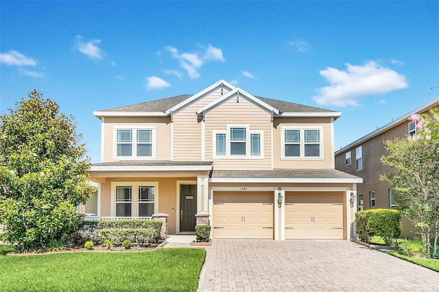 craftsman house with an attached garage, covered porch, a shingled roof, decorative driveway, and a front yard