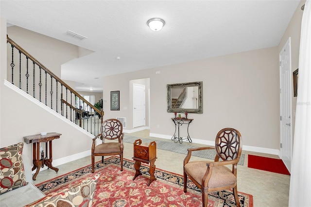 sitting room with baseboards, stairs, and visible vents