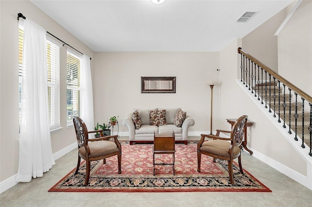 living area with stairs, baseboards, and visible vents