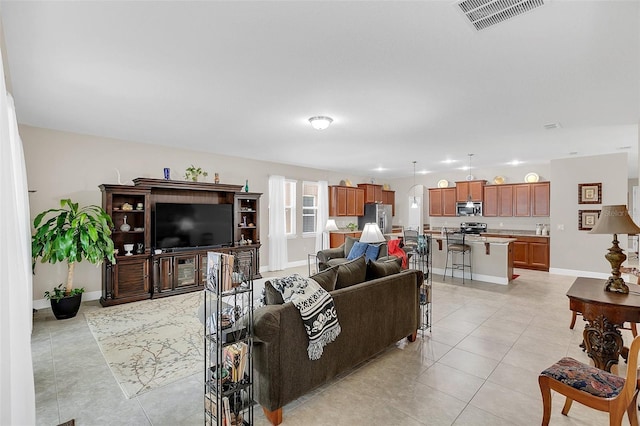 living area with light tile patterned flooring, baseboards, and visible vents
