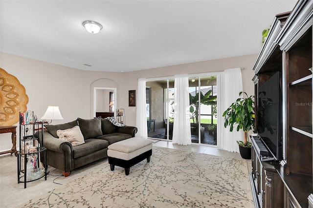 living room with light tile patterned flooring and arched walkways