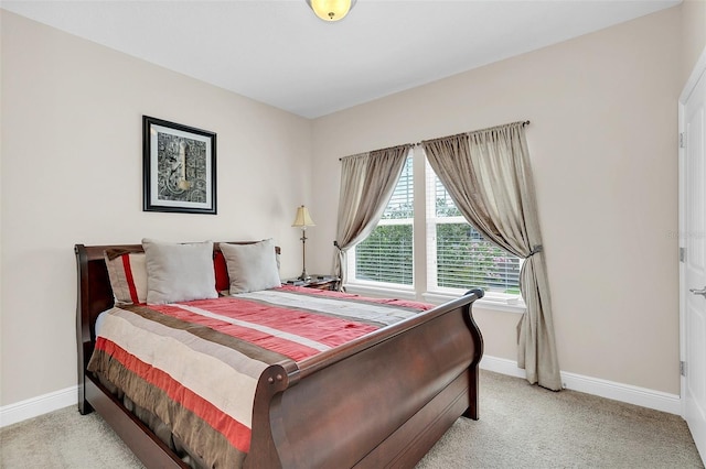 bedroom with light carpet and baseboards