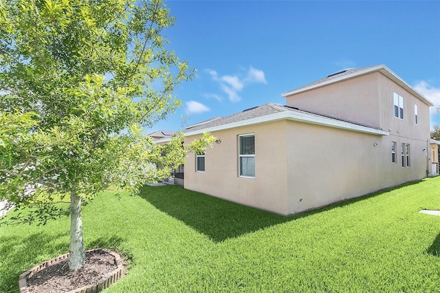 exterior space featuring stucco siding and a lawn