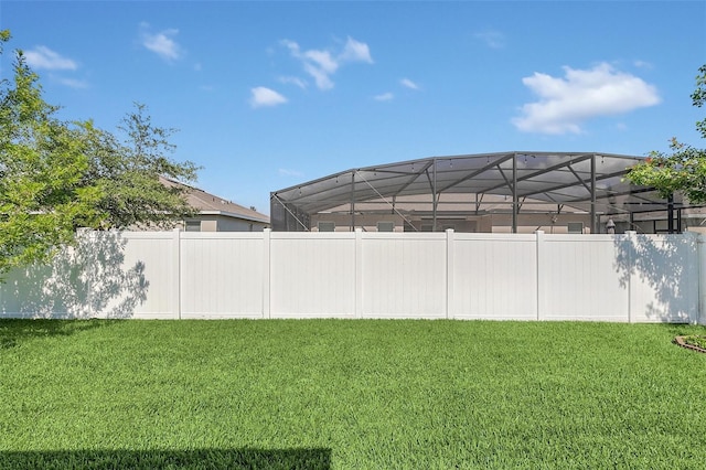 view of yard featuring a fenced backyard and a lanai