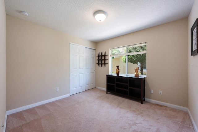 11908 Fiore Dr Unit 1, Orlando, FL 32827 - bedroom featuring light colored carpet, a closet, baseboards, and a textured ceiling
