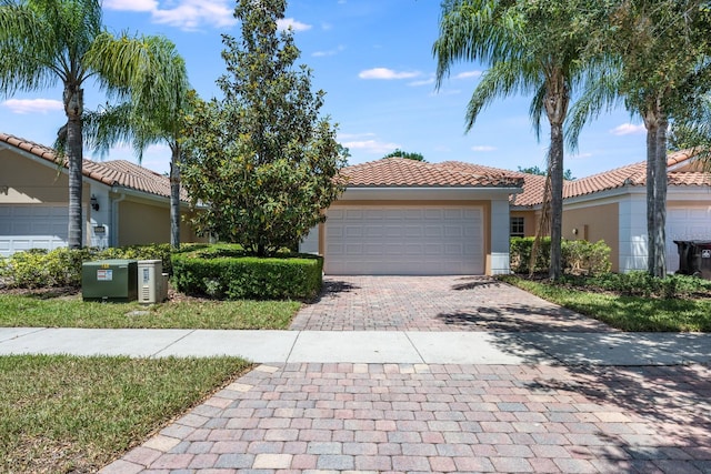 11908 Fiore Dr Unit 1, Orlando, FL 32827 - mediterranean / spanish home with decorative driveway, a tile roof, an attached garage, and stucco siding