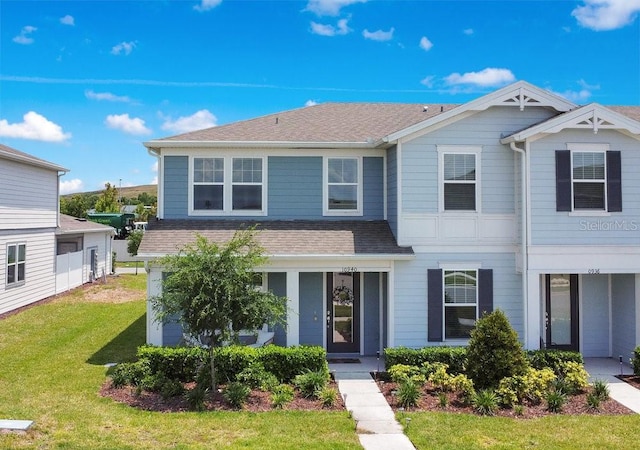 10940 Leafshore Loop, Orlando, FL 32829 - view of front of property featuring a shingled roof, a front lawn, and a porch