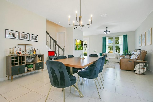 10940 Leafshore Loop, Orlando, FL 32829 - dining room with light tile patterned floors, a chandelier, and stairs