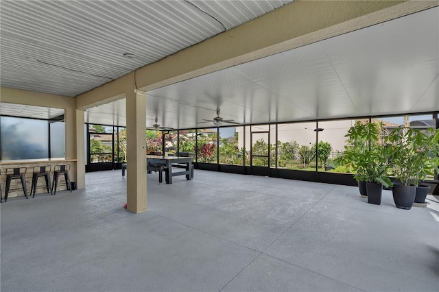 unfurnished sunroom featuring ceiling fan