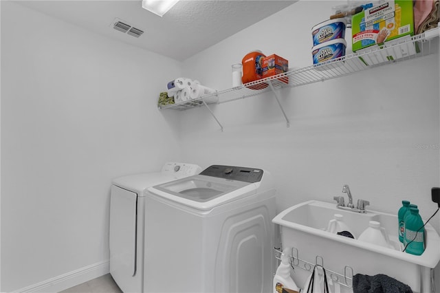 laundry room with washing machine and dryer and baseboards