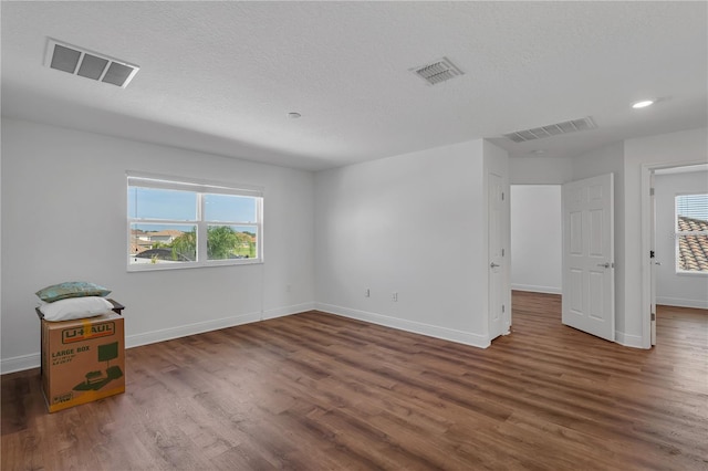 unfurnished room with wood finished floors, baseboards, a textured ceiling, and recessed lighting