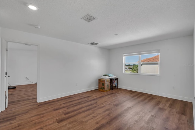 spare room featuring wood finished floors, baseboards, a textured ceiling, and recessed lighting
